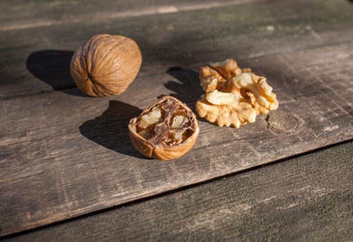 Walnuts over wooden picnic table. Natural light shot