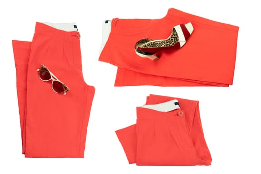 Collage woman clothes. Set of folded red elegant women trousers or denim pants with a matching of elegant single female high heeled shoe and sunglasses. Red fashion concept isolated.