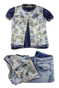 Women jeans fashion. A sleeveless blue jeans vest or jacket for woman on a blue shirt and a folded denim pants and vest isolated on a white background.