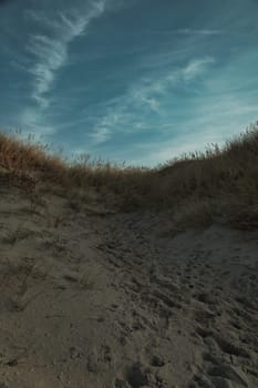 Beach crossing in Denmark by the sea. Dunes, sand water and clouds on the coast. Trip to the Baltic Sea. Vacation on the beach. Scandinavia landscape