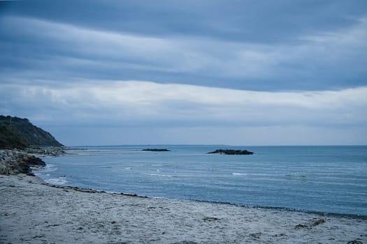 Hundested, Denmark on the cliff overlooking the sea. Baltic Sea coast, grassy meadow, beach. Clouds on horizon. Landscape photo from Scandinavia.