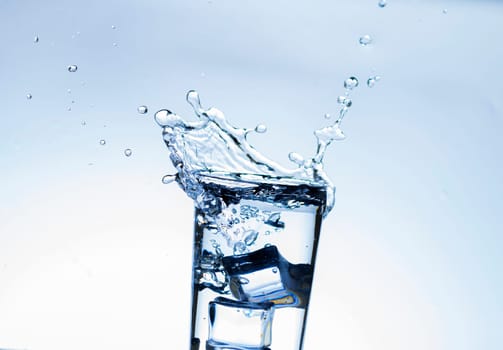 The image of pouring drinking water, into a glass, that makes one feel refreshed on blurred white background, Splashing water, Sparkling water