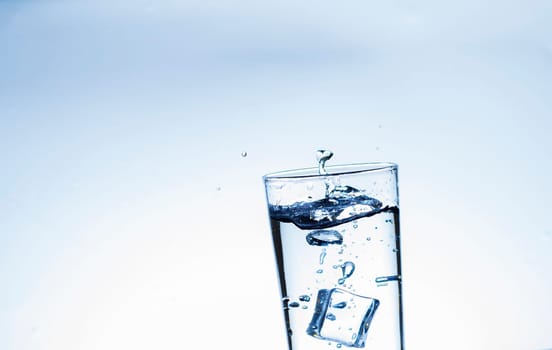 The image of pouring drinking water, into a glass, that makes one feel refreshed on blurred white background, Splashing water, Sparkling water