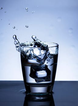 The image of pouring drinking water, into a glass, that makes one feel refreshed on blurred white background, Splashing water, Sparkling water