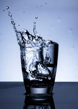 The image of pouring drinking water, into a glass, that makes one feel refreshed on blurred white background, Splashing water, Sparkling water