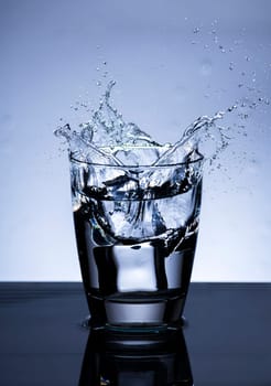The image of pouring drinking water, into a glass, that makes one feel refreshed on blurred white background, Splashing water, Sparkling water