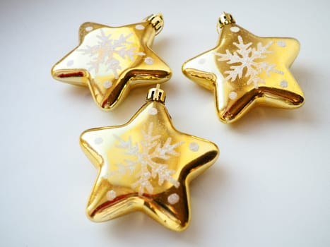 Christmas toys, gold stars on a white background. Beautiful Christmas decorations.