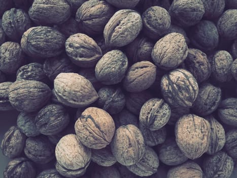 Lots of walnuts close up. Unpeeled walnuts with shells. A bunch of nuts. background. Vegetarian healthy diet. Polyunsaturated fatty acids, omega 3.
