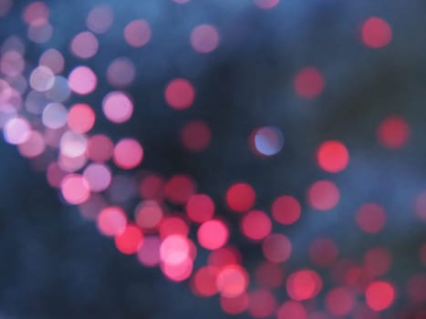 Beautiful side on a dark background. Pink shimmer and circles on a blue and gray background. Festive abstract background.