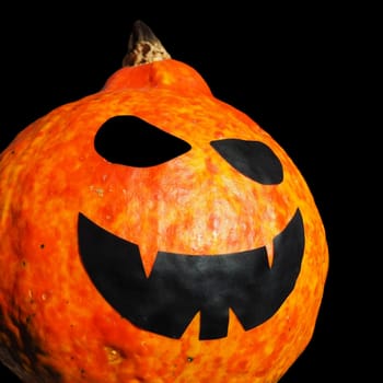 Pumpkin lantern, Halloween attribute. A lantern, carved from a pumpkin, a head with a frightening or funny face. Jack-o-lantern. Will-o-the-wisp. Scary face with a grin on a black background.