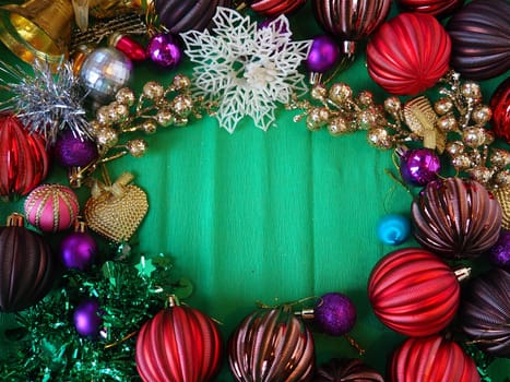 Christmas background with Christmas decoration, holiday balls, bells, bows, Christmas tree rain in a circle. Happy New Year and Merry Christmas. Red, brown, striped, green, gold jewelry. Green middle