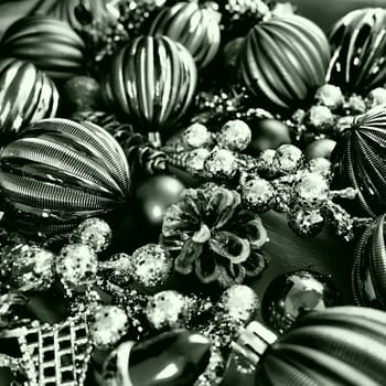 Christmas background with Christmas decorations, holiday balls, bells, bows, fir cone, Christmas tinsel. Happy New Year and Merry Christmas. Black and white monochrome photo with green filter