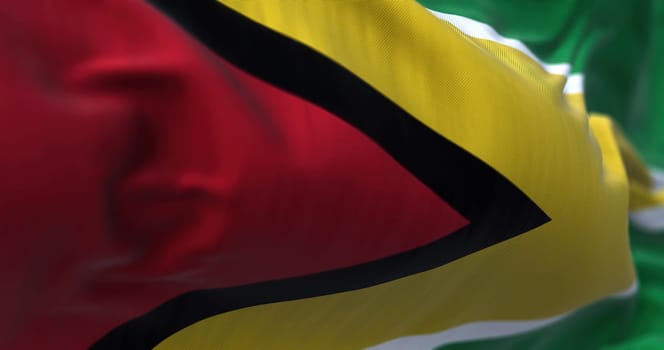 Close-up view of the Guyana national flag waving in the wind. The Co‑operative Republic of Guyana is a country on the northern mainland of South America. Fabric textured background. Selective focus