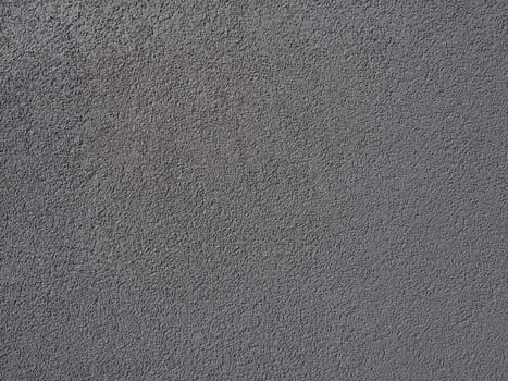 Gray background. Neatly plastered gray or black wall. Rough texture. Velvety effect. Professional finishing of walls, interiors, facades of buildings and premises. Construction and design.
