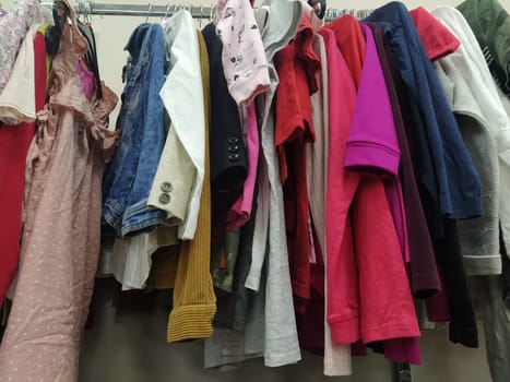 Clothes hung on hangers. Assortment of second hand store. Children's and women's shirts, blouses, sweaters hanging on a rack, ready for sale to customers. Saving money. Belgrade Serbia 22 April 2022