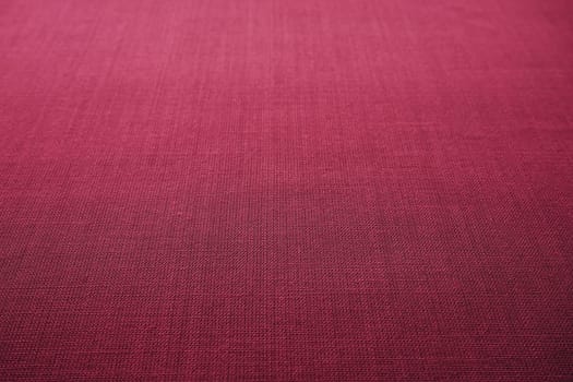 red, burgundy background fabric texture. A piece of woolen cloth is neatly laid out on the surface. Weave and textile texture. Dress fabric or for kitchen needs, tablecloth or curtains, close-up Dash.