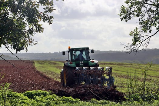 Landwirt pflügt mit seinem Traktor ein Feld nahe der Sababurg, Hessen, Deutschland, Hofgeismar