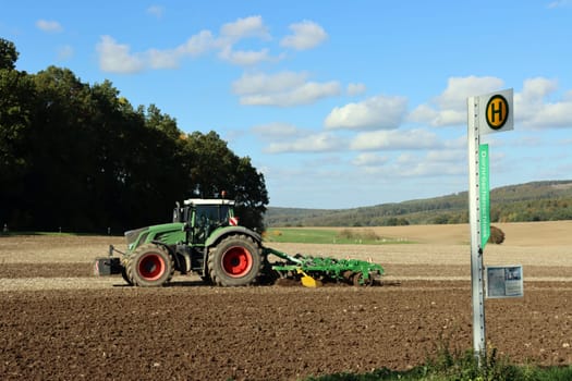 Landwirt eggt mit seinem Traktor ein Feld nahe der Sababurg, Hessen, Deutschland, Hofgeismar
