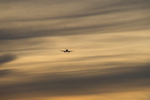 airplane in the evening sky in luminous horizon. vacation trip or cargo transport.