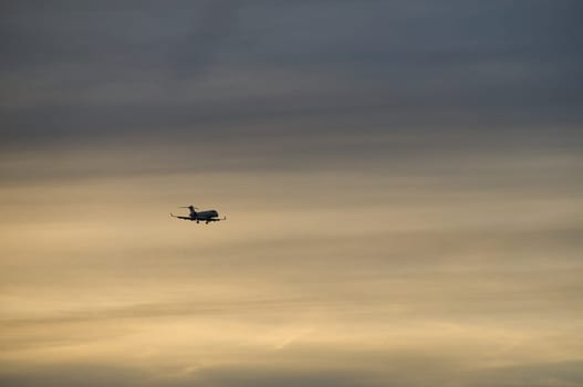 airplane in the evening sky in luminous horizon. vacation trip or cargo transport.