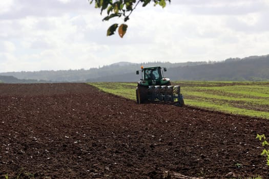 Landwirt pflügt mit seinem Traktor ein Feld nahe der Sababurg, Hessen, Deutschland, Hofgeismar