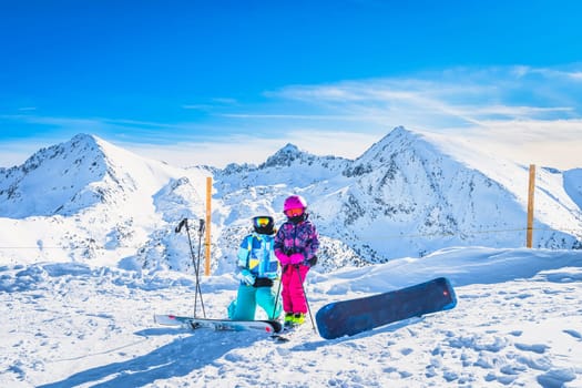 Mother and daughter on ski, winter holidays, with beautiful snow capped mountains in the background in Andorra, El Tarter, Pyrenees Mountains