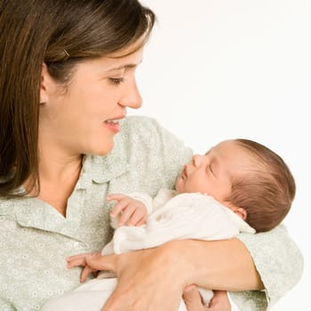 Mother holding baby smiling against white background.
