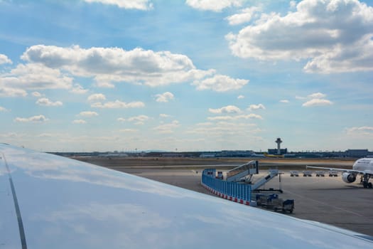 Frankfurt Airport Germany August 02, 2022 - Looking out the window onto an airplane wing with a view of the airport with blue sky