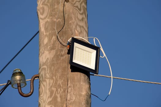 The LED street light is attached to a wooden pole. High quality photo