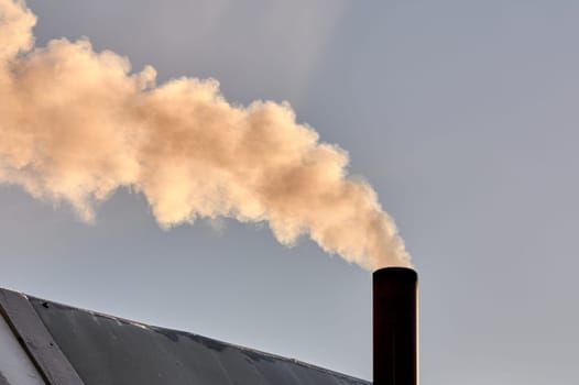 smoke is coming from the chimney of the bourgeoisie. the stove is being heated. High quality photo