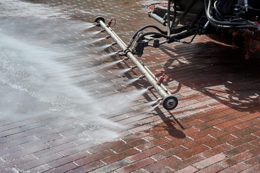 A special machine washes city paths and roads with water. High quality photo