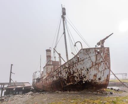 Old, rusty whaling ships and processing facilities at a now abandoned whaling station in Grytviken -on the island of South Georgia.