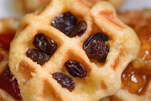 Close up of fresh waffles with dried raisins delicious sweet on top. Making homemade food or dessert at home