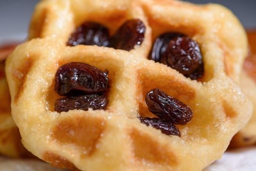 Close up of fresh waffles with dried raisins delicious sweet on top. Making homemade food or dessert at home