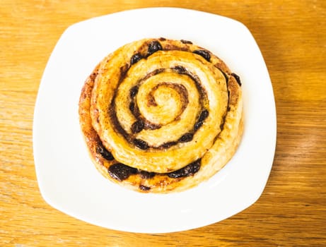 Cinnamon rolls buns baking on a white plate breakfast table Top view.