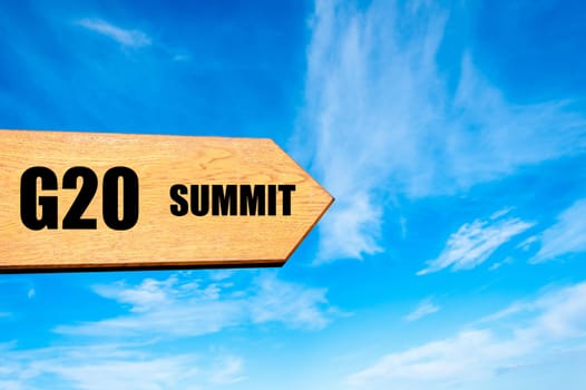 Wooden arrow sign pointing destination  G20 SUMMIT against clear blue sky with copy space available. Travel destination concept  image