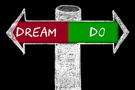 Opposite arrows with Dream versus Do. Hand drawing with chalk on blackboard. Choice conceptual image