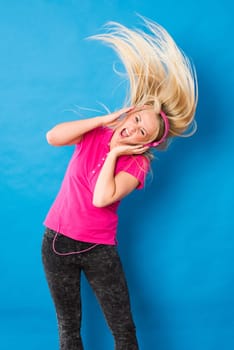 Young blonde woman listens to music and rocks off