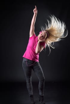 Young blonde woman listens to music and rocks off