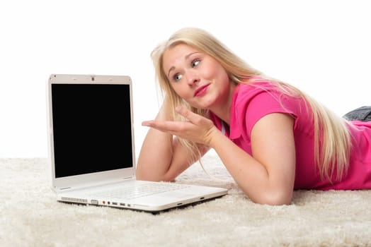 Blonde girl with laptop lies on the floor