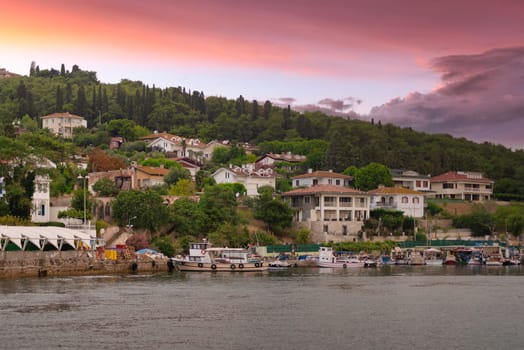 View of the mountains of Kinaliada island from Marmara Sea, with traditional summer houses and docked boats, at sunrise, Istanbul, Turkey