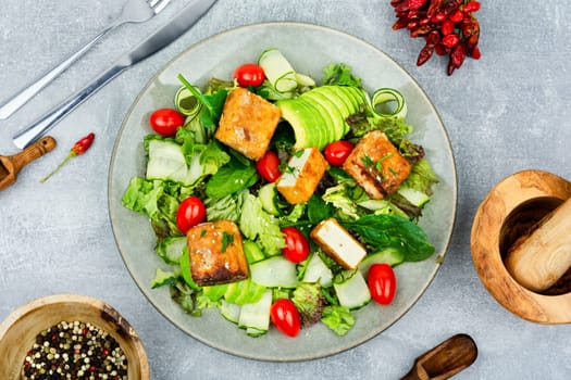 Tasty salad of greens, cucumber, avocado, tomatoes and grilled tofu soy cheese. Healthy Vegetarian Meals