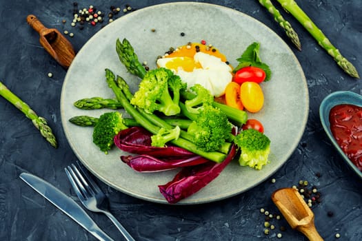 Tasty salad with asparagus, lettuce and poached egg.Copy space