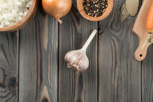 Unpeeled spicy garlic. Layout of dry garlic head on kitchen wooden table. Flat lay view. Fragrant flavorings and vegetables. Prepare ingredients for cooking, recipe. Healthy diet, food.