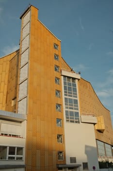 Vertical shot of an imposing golden facade of the Berlin Philharmonic Hall in Berlin, Germany