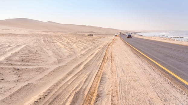 Road from Swakopmund to Walvis bay in Namibia among the Namib-Naukluft desert dunes and the Atlantic Ocean.