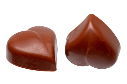 Fine milk chocolate chocolates in the shape of a heart isolated on a white background. Macro.
