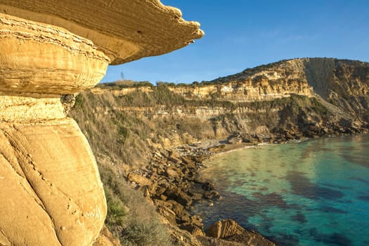 Sunrise light bathing the eroded surface at Cama de Vaca cliffs, Faro District, Lagos, Portugal