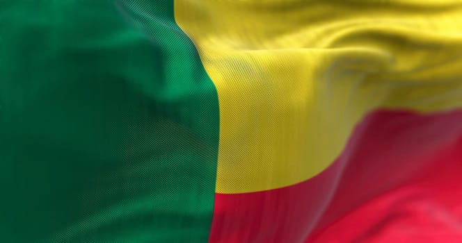 Close-up view of the Benin national flag waving in the wind. The Republic of Benin is a country in West Africa. Fabric textured background. Selective focus. Realistic 3d illustration