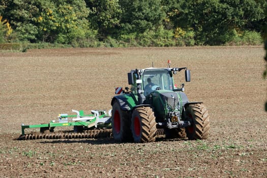 Landwirt eggt mit seinem Traktor ein Feld nahe der Sababurg, Hessen, Deutschland, Hofgeismar